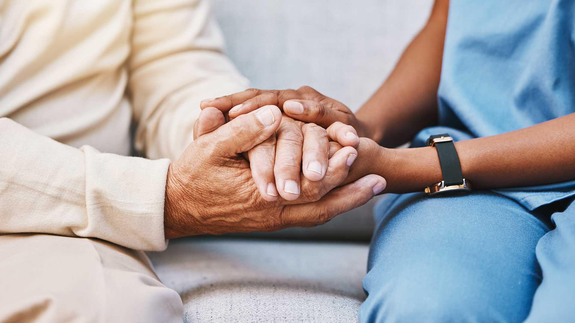 a senior care resident and a community caregiver share a moment while holding hands